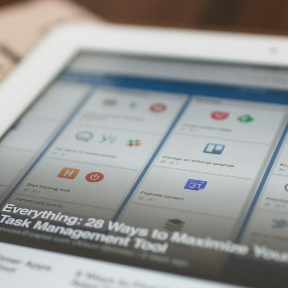 white tablet computer on top of newspaper